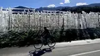 Seorang wanita melewati pohon apel beku yang ditutupi dengan es di dekat Bressanone, South Tyrol, Italia (8/4/2021). Petani apel melindungi bunga apel yang mekar dari pembekuan selama suhu rendah malam dengan membekukannya dengan sistem sprinkler di atas pohon. (AP Photo/Matthias Schrader)