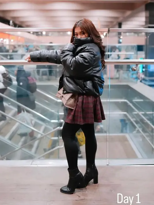 Gaya kece Kiky Saputri liburan di London dengan puffer jacket, plaids mini skirt, stocking, dan sepatu boots. [@kikysaputrii]