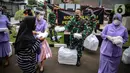 Warga menerima nasi kotak serta masker dari TNI di Markas Komando Gabungan Wilayah I, Jakarta, Selasa (21/4/2020). Dalam rangka Hari Kartini, TNI membagikan makanan dan masker kepada masyarakat. (Liputan6.com/Faizal Fanani)