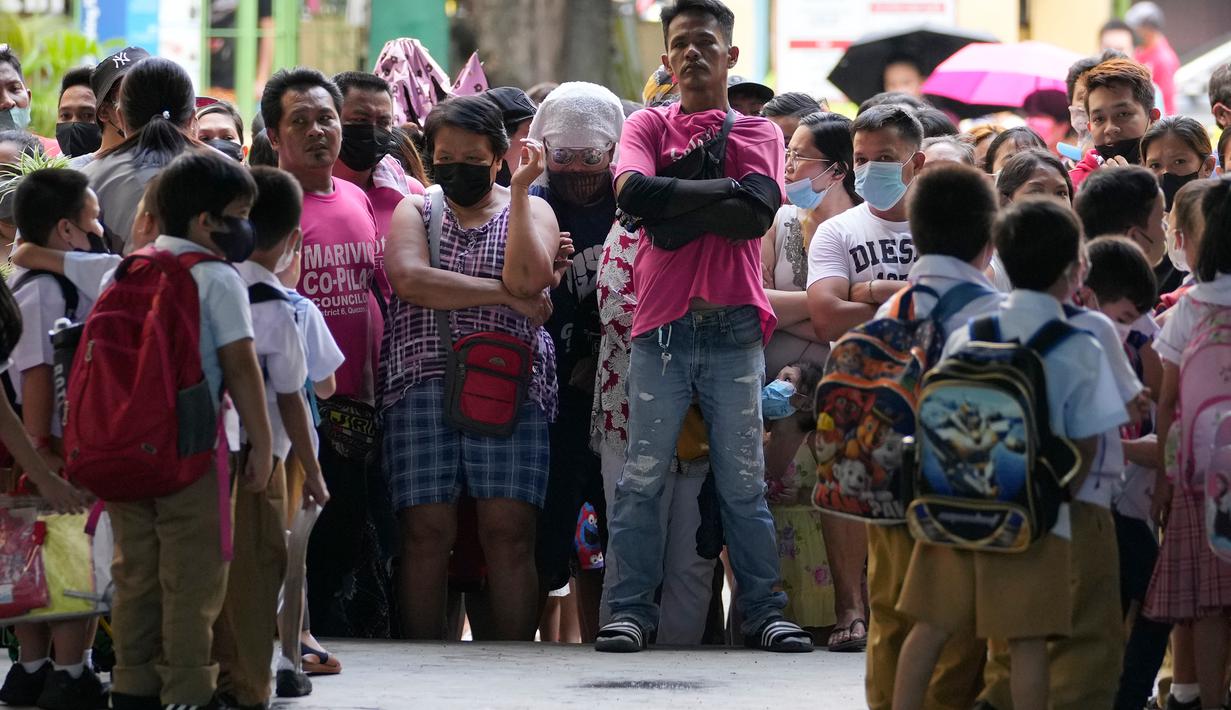 Wali murid menunggu siswa di sekolah umum di Kota Quezon, Filipina pada Rabu (2/11/2022). Jutaan siswa kembali ke sekolah umum di seluruh Filipina saat pemerintah memberlakukan kembali pembelajaran di kelas secara tatap muka setelah lebih dari dua tahun lockdown akibat pandemi virus corona. (AP Photo/Aaron Favila)