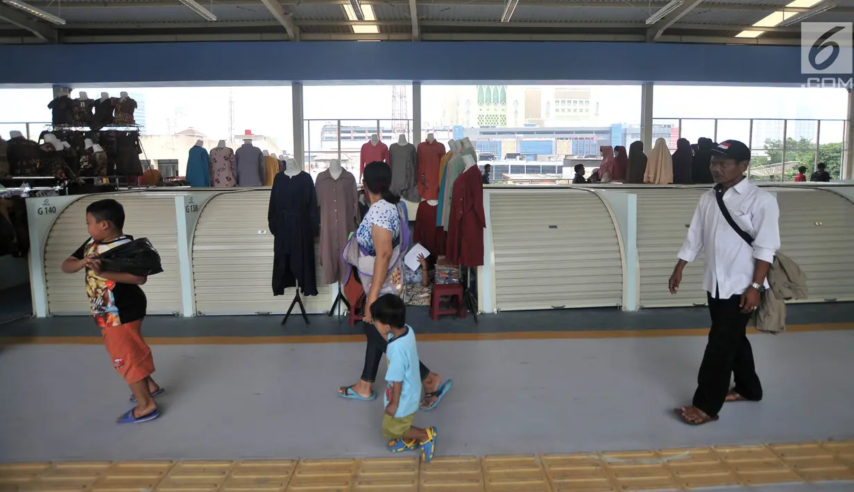 Pengunjung melintasi sejumlah kios pedagang di Skybridge atau jembatan multiguna Tanah Abang, Jakarta, Selasa (11/12). Sejumlah kios masih terlihat tutup. (Merdeka.com/Iqbal Nugroho)