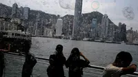 Pengunjung mengambil gambar gelembung yang berterbangan selama pertunjukan seni Bubble Up yang dibuat oleh seniman asal Jepang, Shinji Ohmaki, di Hong Kong, 2 Agustus 2017. (AP Photo/Kin Cheung)