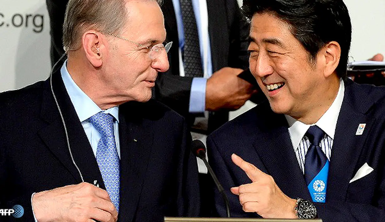 PM Jepang Shinzo Abe (kanan) berbicara dengan Presiden IOC Jacques Roggesetelah Tokyo diumumkan sebagai pemenang tawaran menjadi tuan rumah Olimpiade Musim Panas 2020. (AFP/Fabrice Coffrini)