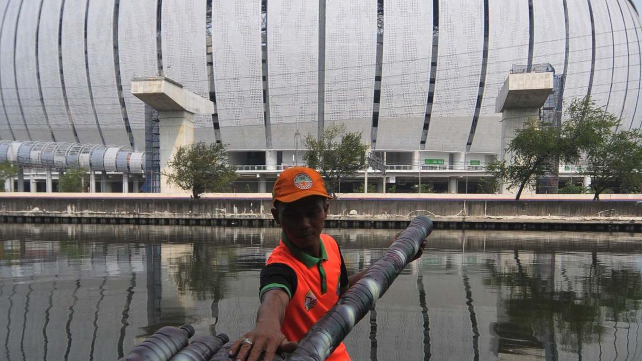 Petugas UPS Badan Air Dinas Lingkungan Hidup DKI Jakarta mengambil sampah menggunakan perahu yang terbuat dari sampah botol plastik di aliran Kali Ancol, Jalan Martadinata, Jakarta Utara, Rabu (22/5/2024).&nbsp;Foto: Merdeka.com/Imam Buhori