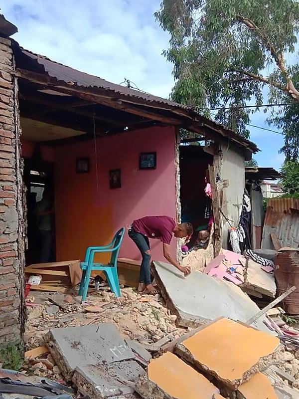 Seorang warga memeriksa tembok rumahnya yang ambruk setelah gempa berkekuatan 6,8 di Ambon, kepulauan Maluku (26/9/2019). Gempa bumi magnitudo 6,8 guncang kawasan timur Indonesia tepatnya di Ambon Maluku Kamis (26/9/2019) pagi. (AFP Photo/Aisyah Putri)