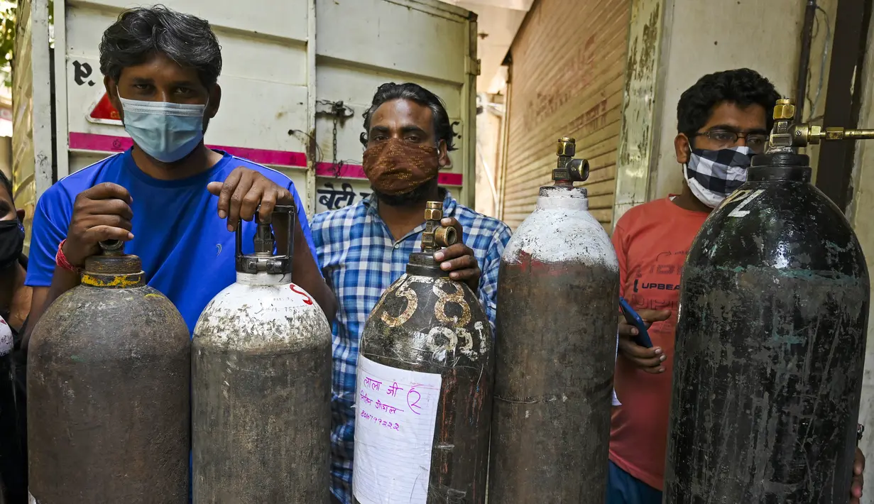 Orang-orang mengantre untuk mengisi tabung oksigen untuk pasien virus corona di pusat pengisian ulang di New Delhi, Rabu (5/5/2021). India mengalami lonjakan kembali kasus COVID-19 dan menyebabkan kurangnya pasokan oksigen serta obat-obatan esensial di rumah-rumah sakit. (Tauseef MUSTAFA/AFP)
