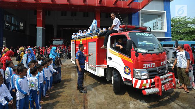 Sejumlah siswa TK di lingkungan Kabupaten Bogor menaiki mobil pemadam kebakaran saat berkunjung ke kantor Dinas Pemadam Kebakaran, Jalan Tegar beriman, Cibinong, Rabu (18/9/2019). Kegiatan belajar di luar kelas ini untuk mengenalkan profesi dan tugas pemadam kebakaran. (merdeka.com/Arie Basuki)