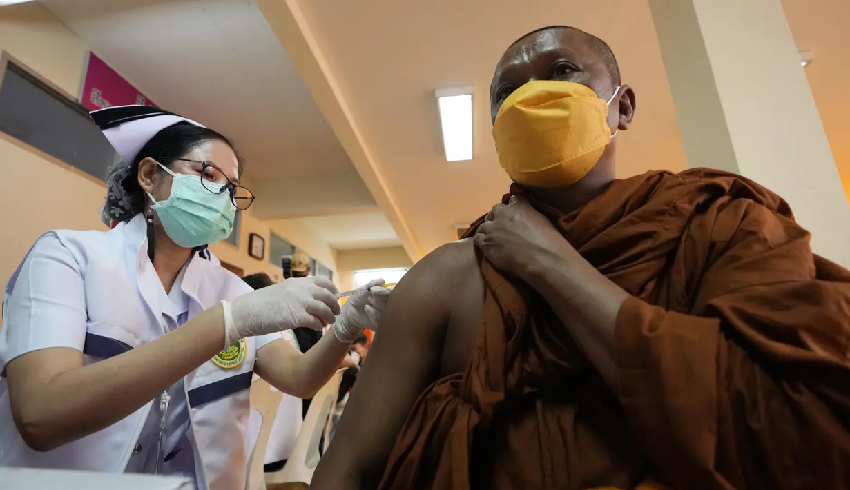 Petugas kesehatan menyuntikan vaksin kepada biksu Buddha di Wat Srisudaram di Bangkok, Thailand (30/7/2021). Thailand sedang berjuang untuk menahan wabah terbarunya yang dipicu oleh varian Delta yang sangat menular, dengan infeksi dan kematian yang meroket. (AP Photo/Sakchai Lalit)