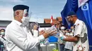 Calon Wali Kota Depok nomor urut 2 Mohammad Idris mengenakan sarung tangan plastik saat akan menggunakan hak pilihnya di TPS 14 Jatimulya, Depok, Rabu (9/12/2020). Pilkada Depok 2020 diikuti oleh Pradi Supratna-Afifah Alia serta Mohammad Idris dan Imam Budi Hartono. (Liputan6.com/Herman Zakharia)