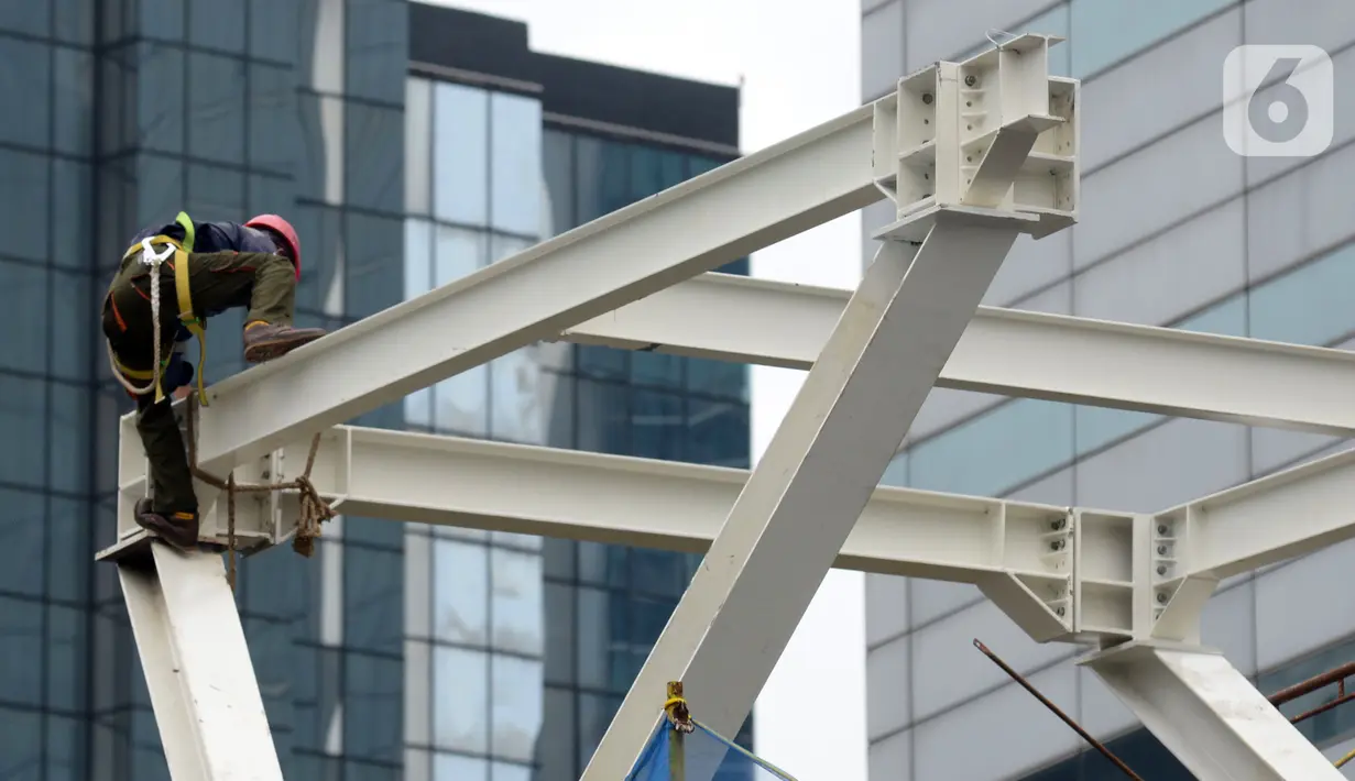 Pekerja menyelesaikan proyek Tugu Tenaga Kesehatan di Jembatan Penyeberangan Orang (JPO) Sudirman, Jakarta, Jumat (12/11/2021). Tugu Tenaga Kesehatan dibangun sebagai monumen perjuangan dan pengorbanan tenaga medis dalam menangani COVID-19. (merdeka.com/Imam Buhori)