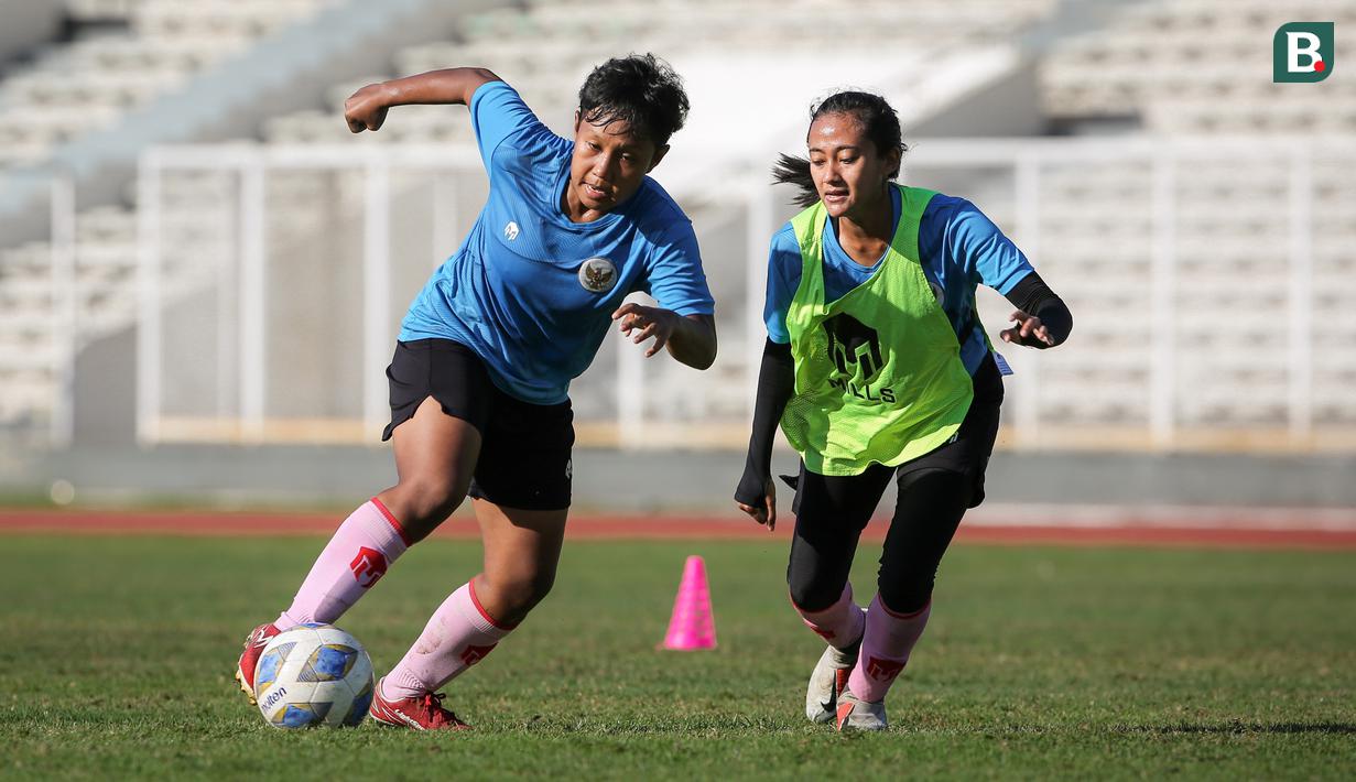 Pemain Timnas Wanita Indonesia, Nisma Francida Rusdiana (kiri) berebut bola dengan Diah Tri Lestari saat sesi latihan persiapan Piala Asia Wanita 2022 di Stadion Madya, Jakarta, Jumat (07/01/2021). (Bola.com/Bagaskara Lazuardi)