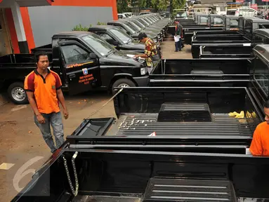 Petugas memeriksa mesin kendaraan operasional di kantor Dinas Kebersihan DKI Jakarta, di Cililitan, Jakarta, Jumat (23/10). Sebanyak 77 mobil pick up diberikan sebagai kendaraan operasional pengawas kebersihan kota. (Liputan6.com/Gempur M Surya)