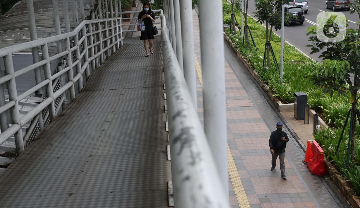 Warga mengenakan masker berjalan di pedestrian Jalan Jenderal Sudirman, Jakarta, Kamis (5/11/2020). BPS mencatat ekonomi Indonesia pada kuartal III-2020 minus 3,49 persen, Indonesia dipastikan resesi karena pertumbuhan ekonomi dua kali mengalami minus. (Liputan6.com/Helmi Fithriansyah)