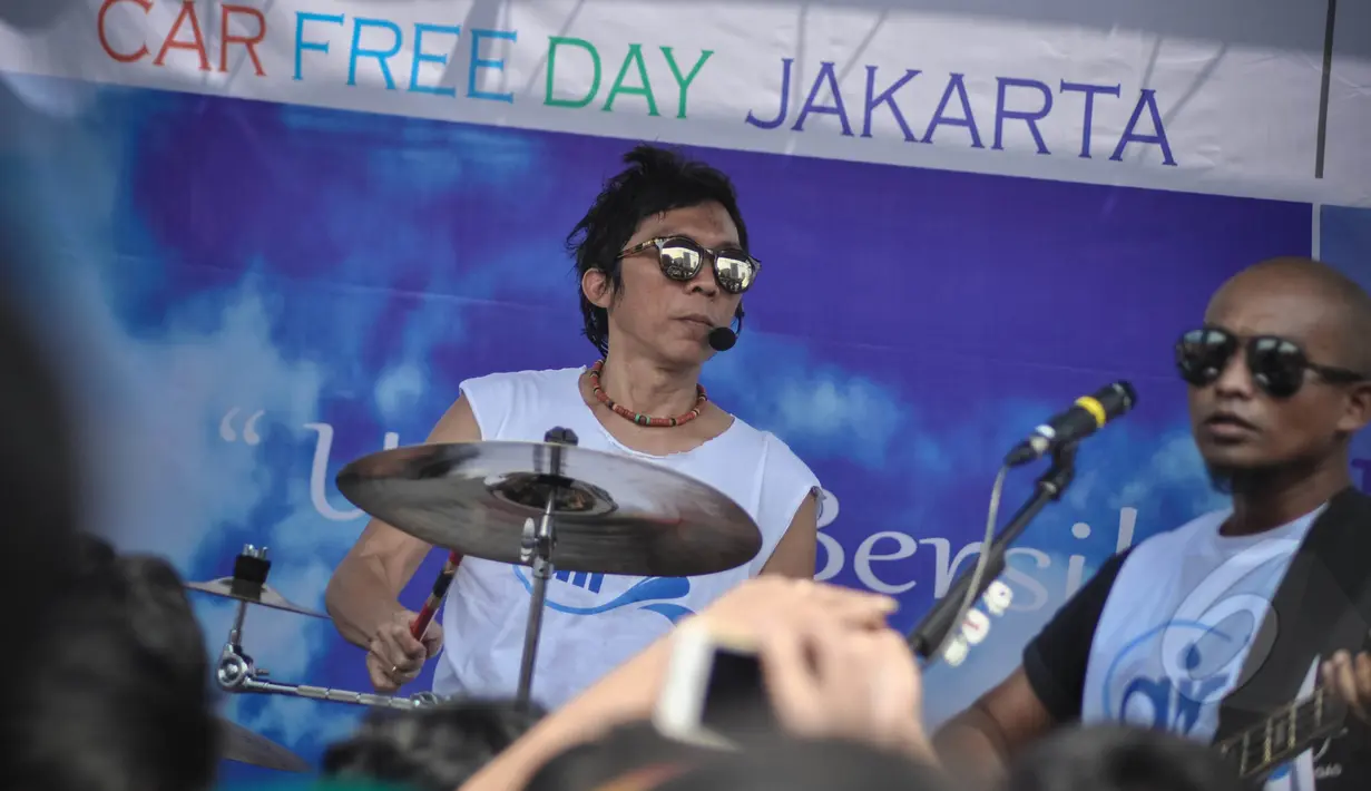 Personel Slank, Bimbim dan Ivan saat menghibur warga Ibukota di Bundaran HI, Jakarta, Minggu (22/3/2015). Grup musik ini menggelar konser mini untuk memperingati Hari Air Sedunia yang jatuh pada 22 Maret. (Liputan6.com/Faizal Fanani) 