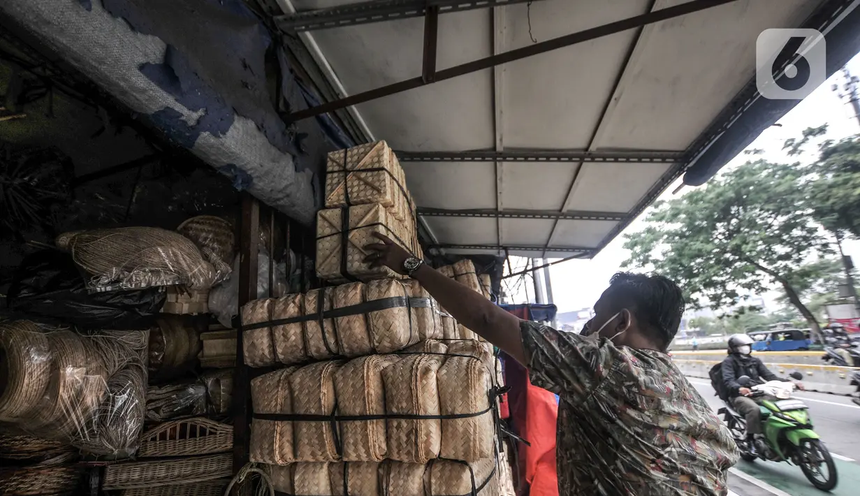 Pembeli memilih besek bambu di kawasan Jatinegara, Jakarta, Senin (19/7/2021). Pedagang mengaku harga jual besek bambu tetap stabil dengan kisaran Rp3.000 hingga Rp5.000 per buah. (merdeka.com/Iqbal S. Nugroho)