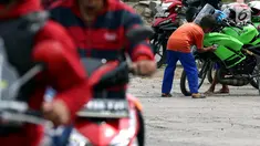 Seorang anak membersihkan motor yang di kendarai pemudik dari Jakarta menuju kampung halamannya di SPBU Tanjung Pantura - Brebes, Kamis (22/6). Memanfaatkan moment mudik anak - anak pantura mengais rejeki untuk lebaran 1438 H. (Liputan6.com/Johan Tallo)