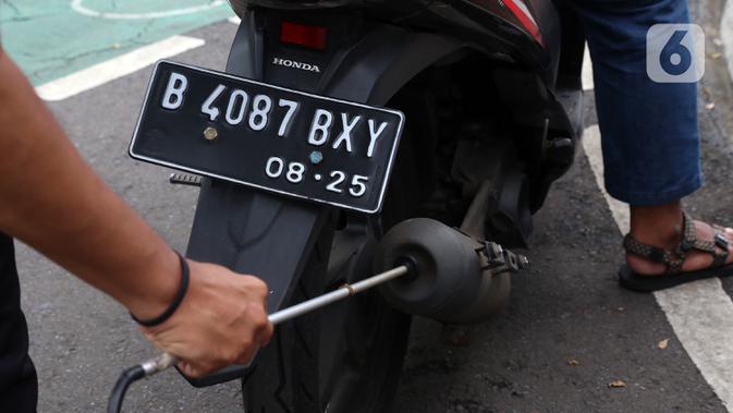 Petugas memeriksa emisi motor di Jakarta Barat, Rabu (13/1/2021). Dinas Lingkungan Hidup DKI Jakarta mengumumkan kendaraan yang tidak mengikuti uji emisi atau tidak lulus uji emisi gas buang akan dikenakan disinsentif tarif parkir yang tinggi dan tilang. (Liputan6.com/Angga Yuniar)