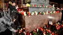 Warga meletakkan lilin dan bunga saat berkabung untuk para korban penembakan brutal di Hanau, Jerman, Kamis (20/2/2020). Warga menyalakan lilin dan membawa mawar berkumpul dalam diam. (AP Photo/Martin Meissner)