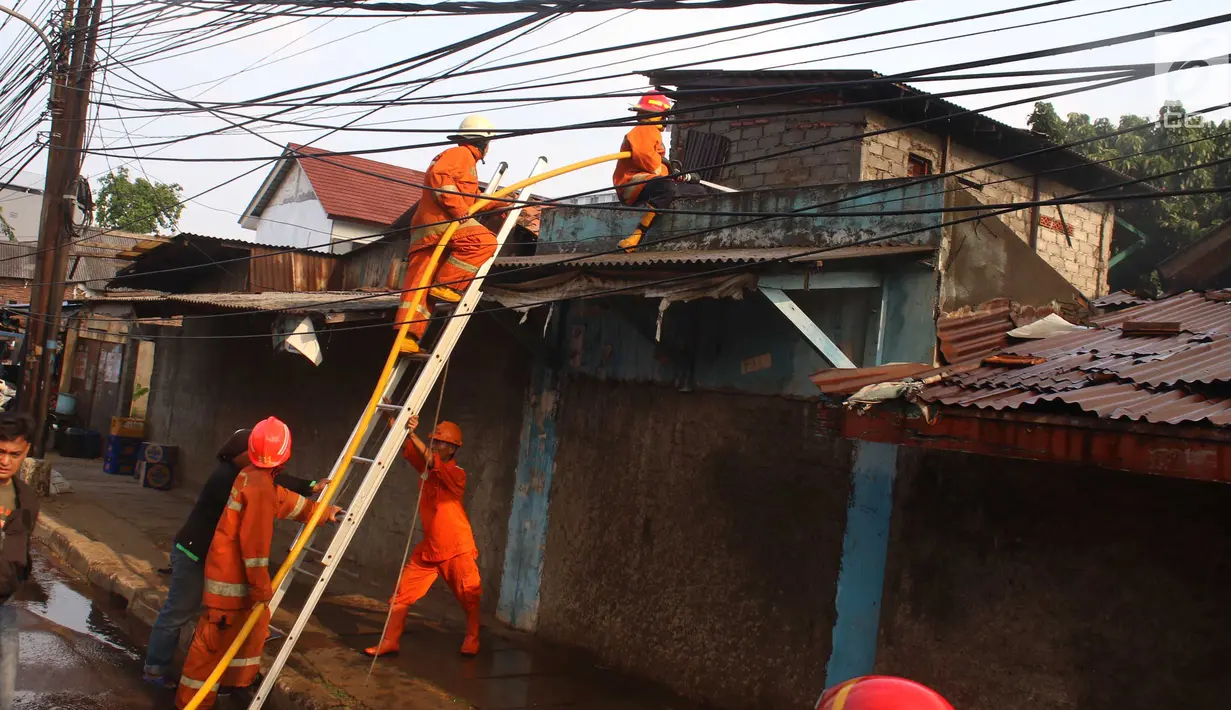 Petugas pemadam kebakaran berupaya memadamkan api yang membakar sebuah percetakan dan pabrik roti di Jalan Cawang Baru, Kavling Otista, Jakarta, Selasa (19/9). Dugaan sementara, kebakaran terjadi karena arus pendek listrik. (Liputan6.com/Angga Yuniar)