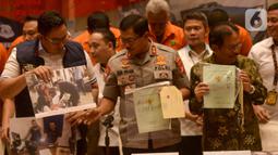 Kapolda Metro Jaya Rijen Pol Nana Sujana (tengah) bersama Menteri ATR/BPN Sofyan A. Djalil (kanan) menunjukkan barang bukti sertifikat tanah palsu saat rilis kasus sindikat mafia tanah di Jakarta, Rabu (12/2/2020). (merdeka.com/Imam Buhori)