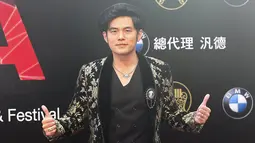 Penyanyi Taiwan, Jay Chou mengacungkan kedua jempolnya saat berpose di red carpet acara 26th Golden Melody Awards di Taipei, Sabtu (27/6/2015). (REUTERS/Toby Chang)