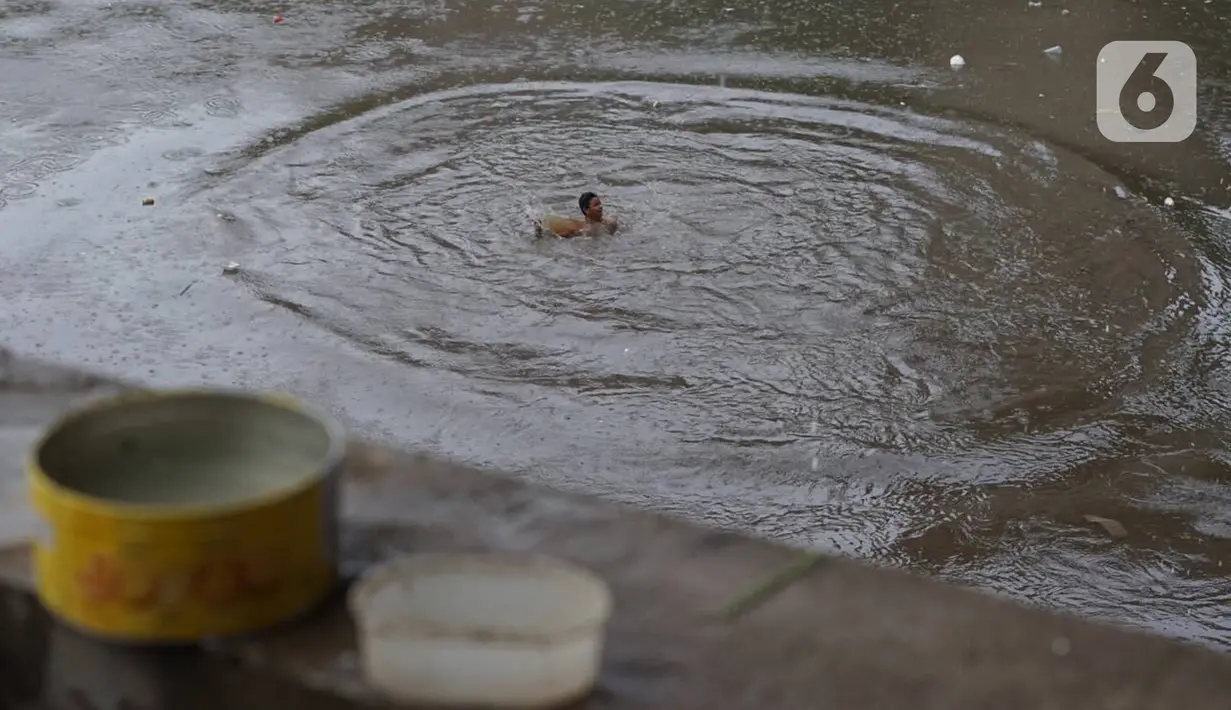 Anak-anak berenang di Sungai Ciliwung, Rawajati, Jakarta, Selasa (17/12/2019). Meski debit air Sungai Ciliwung naik akibat hujan mengguyur Jakarta sejak siang hingga sore, anak-anak tersebut tetap nekat berenang tanpa memedulikan keselamatan. (Liputan6.com/Immanuel Antonius)