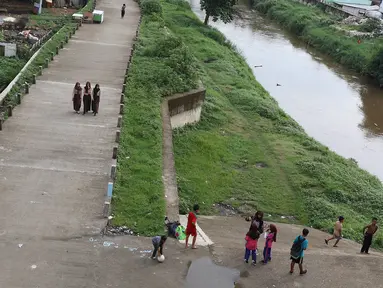 Anak-anak bermain sepak bola di jalur inspeksi Sungai Ciliwung di kawasan Rawajati, Jakarta, Rabu (23/1). Keterbatasan lahan tidak menyurutkan semangat mereka untuk bermain sepak bola meski di tempat seadanya. (Liputan6.com/Immanuel Antonius)