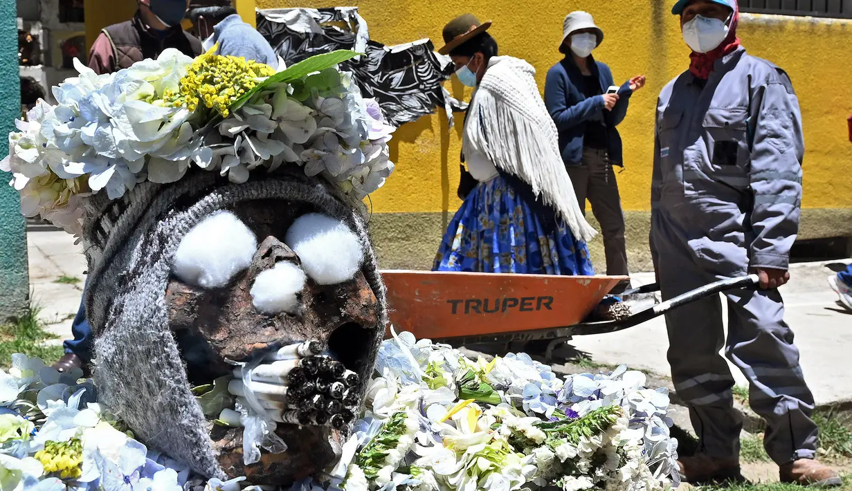 Tengkorak manusia dengan banyak rokok di mulutnya terlihat di pemakaman umum selama festival tahunan "Natitas" di La Paz, Bolivia, Senin (8/11/2021). Dalam festival ini warga ramai-ramai menghias tengkorak leluhur mereka dengan berbagai dekorasi. (Aizar RALDES/AFP)