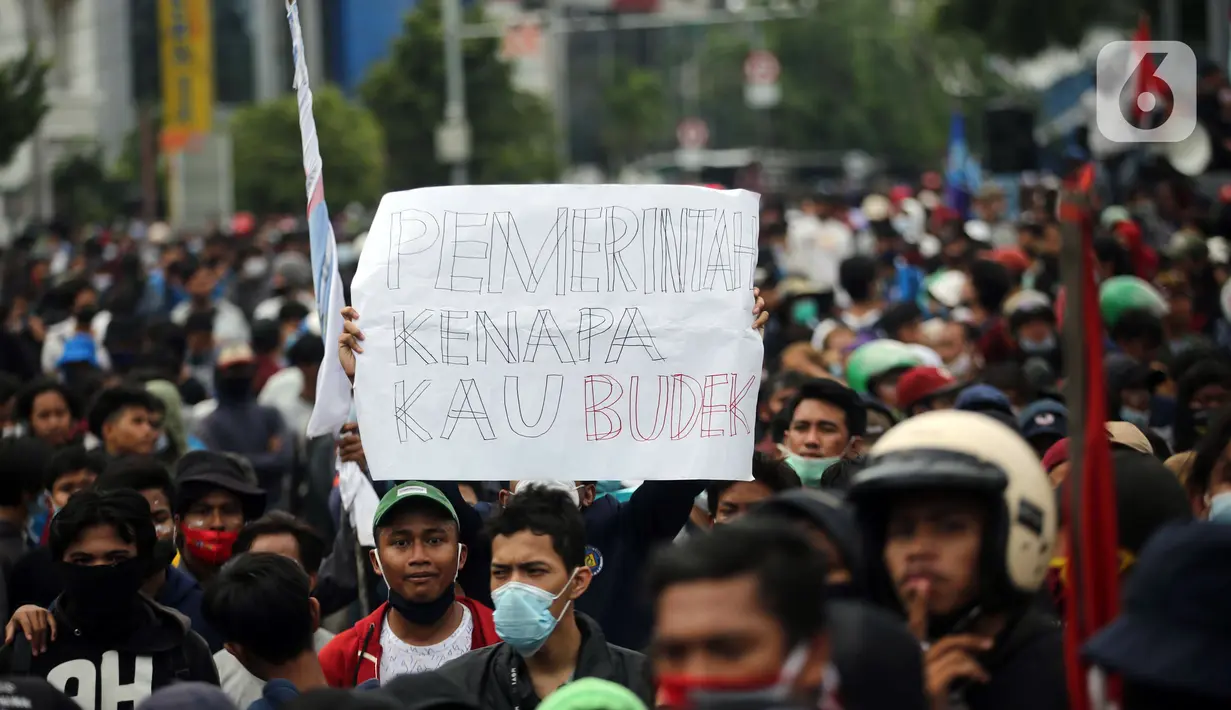 Pengunjuk rasa mengangkat poster saat berdemonstrasi menolak UU Cipta Kerja di kawasan Harmoni, Jakarta, Kamis (8/10/2020). UU Cipta Kerja yang disahkan beberapa waktu lalu memicu demonstasi sejumlah kalangan. (Liputan6.com/Faizal Fanani)