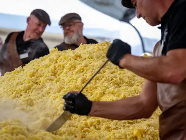 Koki memasak rosti dalam upaya memecahkan rekor dunia saat acara yang menandai peringatan 125 tahun Serikat Petani Swiss (SBV) di Bern, Swiss pada 19 September 2022. Petani Swiss berhasil memecahkan rekor roesti terbesar di dunia yang dibuat di atas wajan berbentuk salib dengan ukuran 13.7 meter persegi. (Fabrice COFFRINI / AFP)