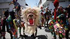 Sejumlah orang menari sambil mengenakan kostum dan topeng saat perayaan tradisional di Naiguata, Venezuela (31/5). Sejumlah orang kerasukan dan menari selama festival yang dikenal Dancing Devils ini di Naiguata. (AP/Arian Cubillos)