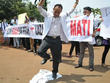 Massa menginjak jas putih khas dokter saat melakukan unjuk rasa di depan Istana Merdeka, Jakarta, Senin (7/9/2015). Mereka memprotes Kemenristek Dikti yang telah menahan ijazah fakultas kedokteran mereka. (Liputan6.com/Gempur M Surya)