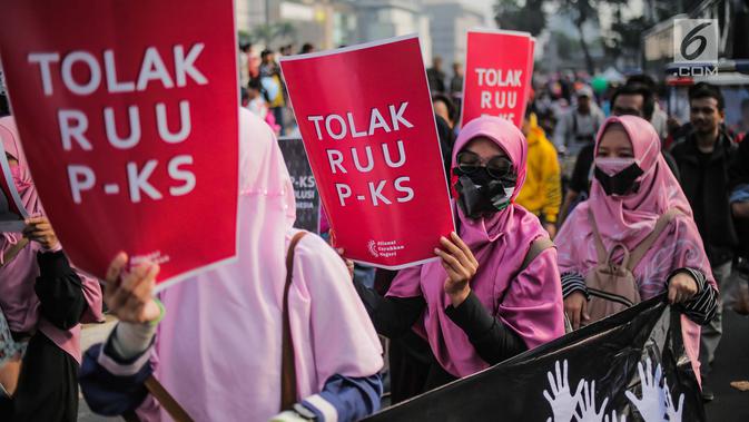 Aktivis Aliansi Gerakan Peduli Perempuan membawa spanduk berisi penolakan terhadap Rancangan Undang-Undang Penghapusan Kekerasan Seksual (RUU PKS) saat car free day di kawasan Bundaran HI, Jakarta, Minggu (14/7/2019). Mereka menolak rencana pengesahan RUU PKS. (Liputan6.com/Faizal Fanani)