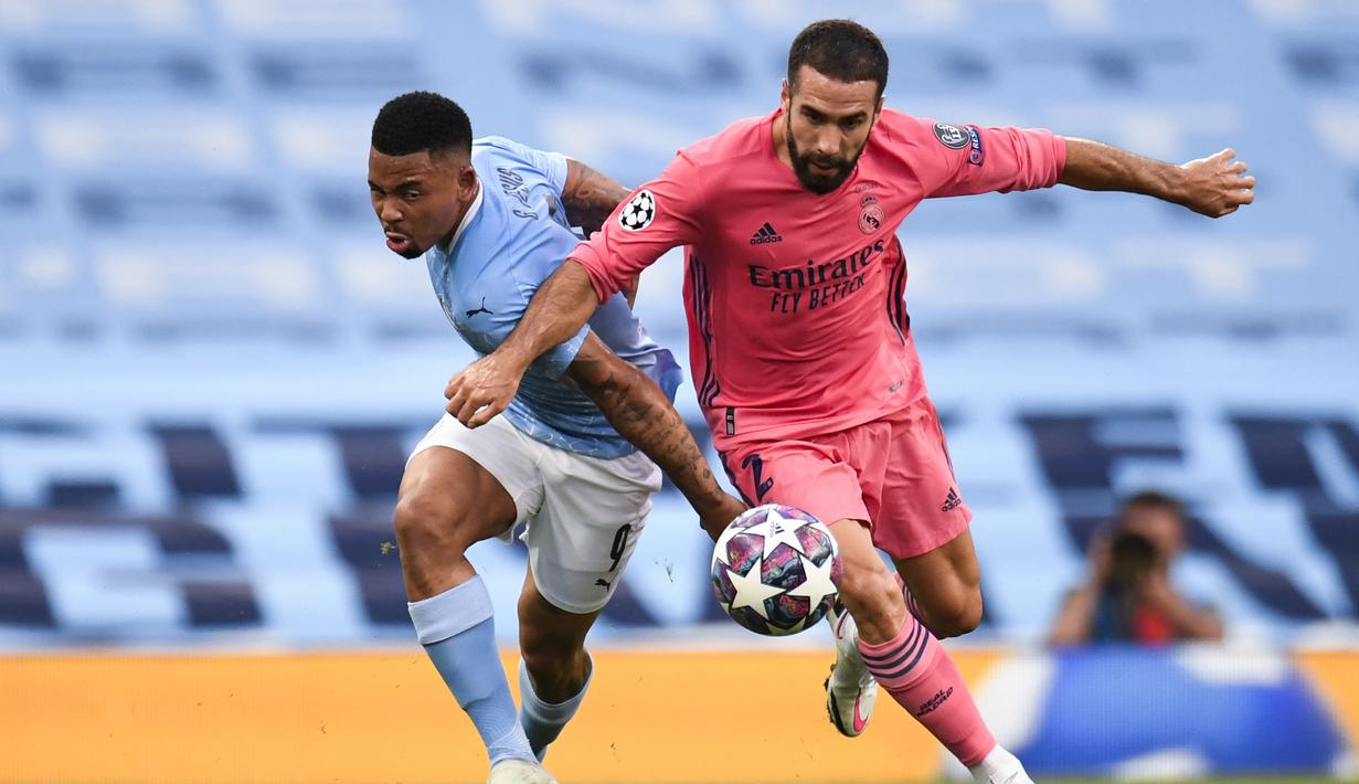 Striker Manchester City, Gabriel Jesus, berebut bola dengan bek Real Madrid, Dani Carvajal, pada laga leg kedua 16 besar Liga Champions di Etihad Stadium, Sabtu (8/8/2020) dini hari WIB. Manchester City menang 2-1 atas Real Madrid. (AFP/Peter Powell/pool)