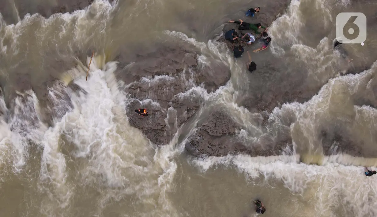 <p>Foto udara menunjukkan wisatawan berenang di aliran sungai Cipamingkis Kecamatan Sukamakmur, kabupaten Bogor, Jawa Barat, Kamis (5/5/2022). Warga memanfaatkan aliran sungai tersebut sebagai sarana hiburan Hari Raya Idul Fitri 1443 Hijriah. (merdeka.com/Imam Buhori)</p>