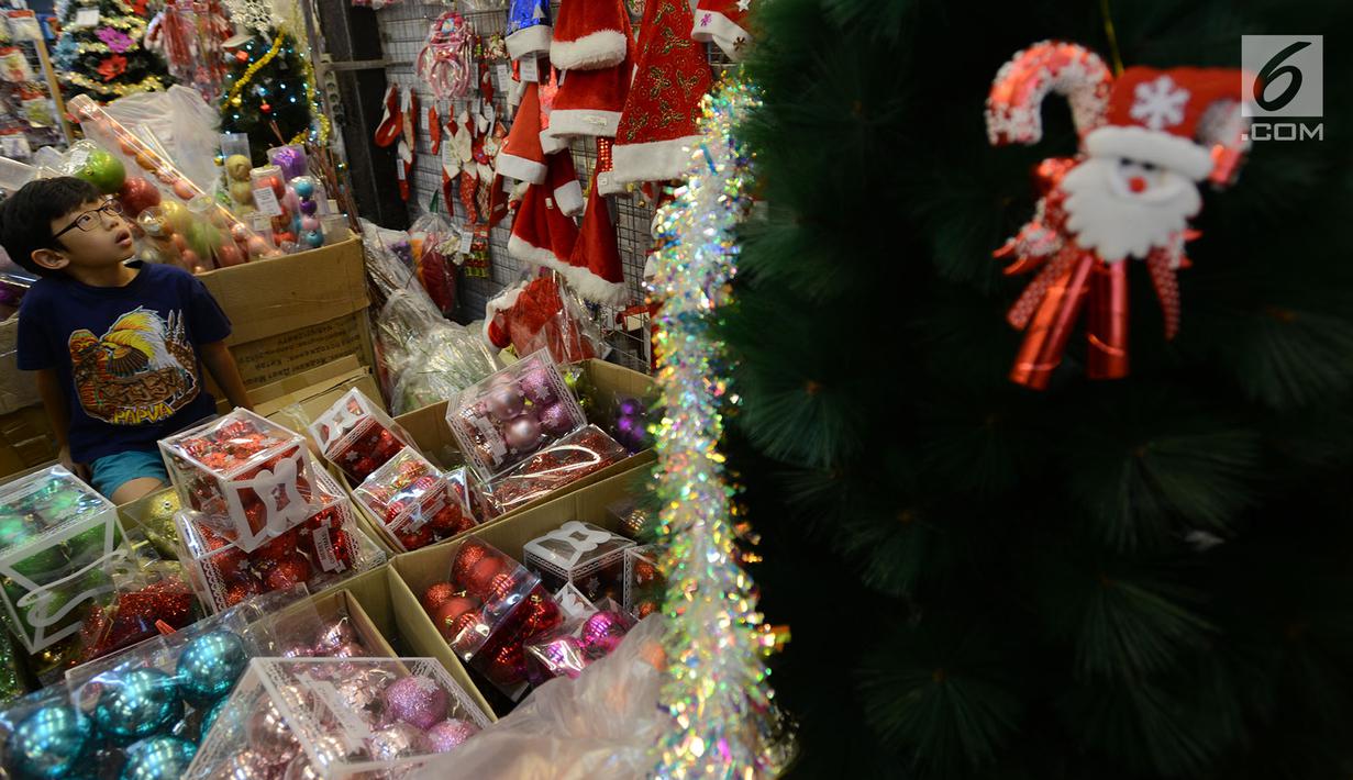 Seorang bocah memilih pernak-pernik perayaan Natal di Pasar Asemka, Jakarta,Kamis (13/12). Pedagang mengaku penjualan pernak-pernik Natal meningkat dari minggu sebeumnya. (Merdeka.com/Imam Buhori)