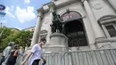 Seorang pejalan kaki berjalan melewati patung Theodore Roosevelt di luar Museum Sejarah Alam Amerika di New York, AS (22/6/2020). Patung Theodore Roosevelt yang menunggangi seekor kuda tu akan dirobohkan, dengan alasan "menggambarkan hirarki rasial," menurut pihak museum. (Xinhua/Wang Ying)