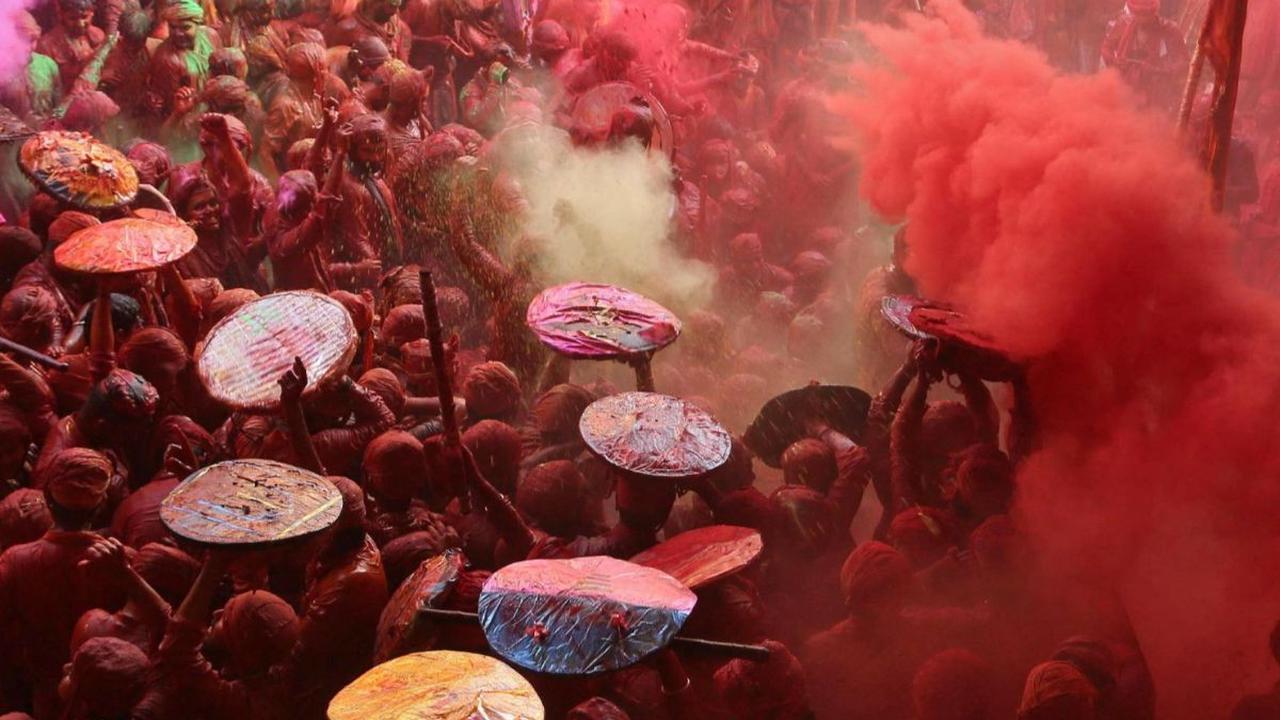 Sejumlah warga saling melempar bubuk warna-warni dalam Festival Lathmar Holi atau Festival Holi di&nbsp;sebuah kuil di Kota Barsana, Uttar Pradesh, India, pada 18 Maret 2024. Festival Holi yang identik dengan perang bubuk warna-warni kembali digelar di be