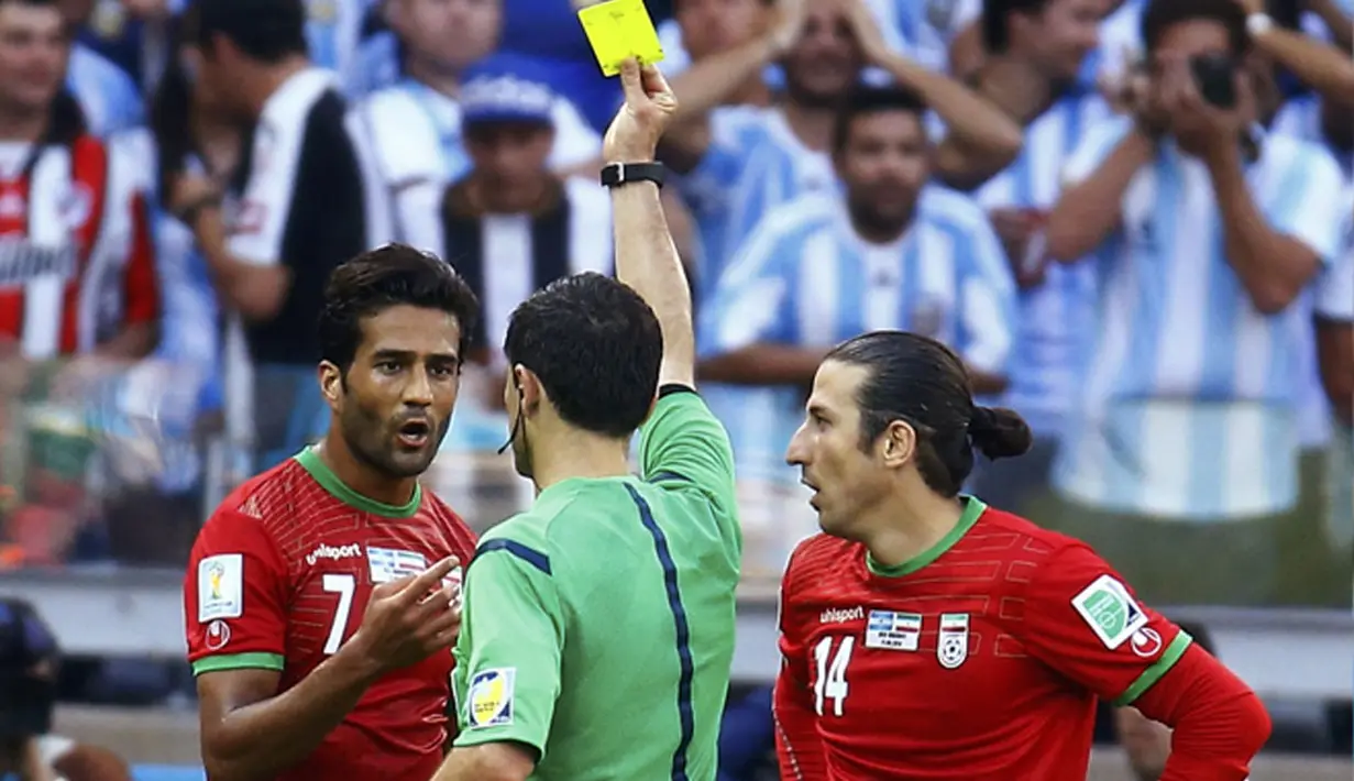 Dua kartu kuning dikeluarkan wasit Milorad Mazic (tengah) di penyisihan Piala Dunia Grup F di Stadion Mineirao, Belo Horizonte, Brasil (21/6/2014), salah satunya diberikan pada Masoud Shojaei (Iran - kiri). (REUTERS/Kai Pfaffenbach)