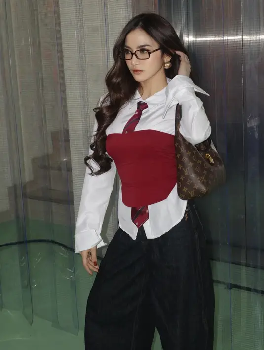 Gaya office look Mahalini semakin stylish dengan menambahkan kemben merah yang senada dengan dasinya. Tampak Mahalini membawa shoulder bag Louis Vuitton.  [@mahaliniraharja]
