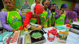 Chef Yeni Ismayani (kedua kiri) saat memberikan pelatihan cara membuat makanan tradisional di Kecamatan Makassar, Jakarta Timur, Selasa (24/5/2016). (Liputan6.com/Yoppy Renato)