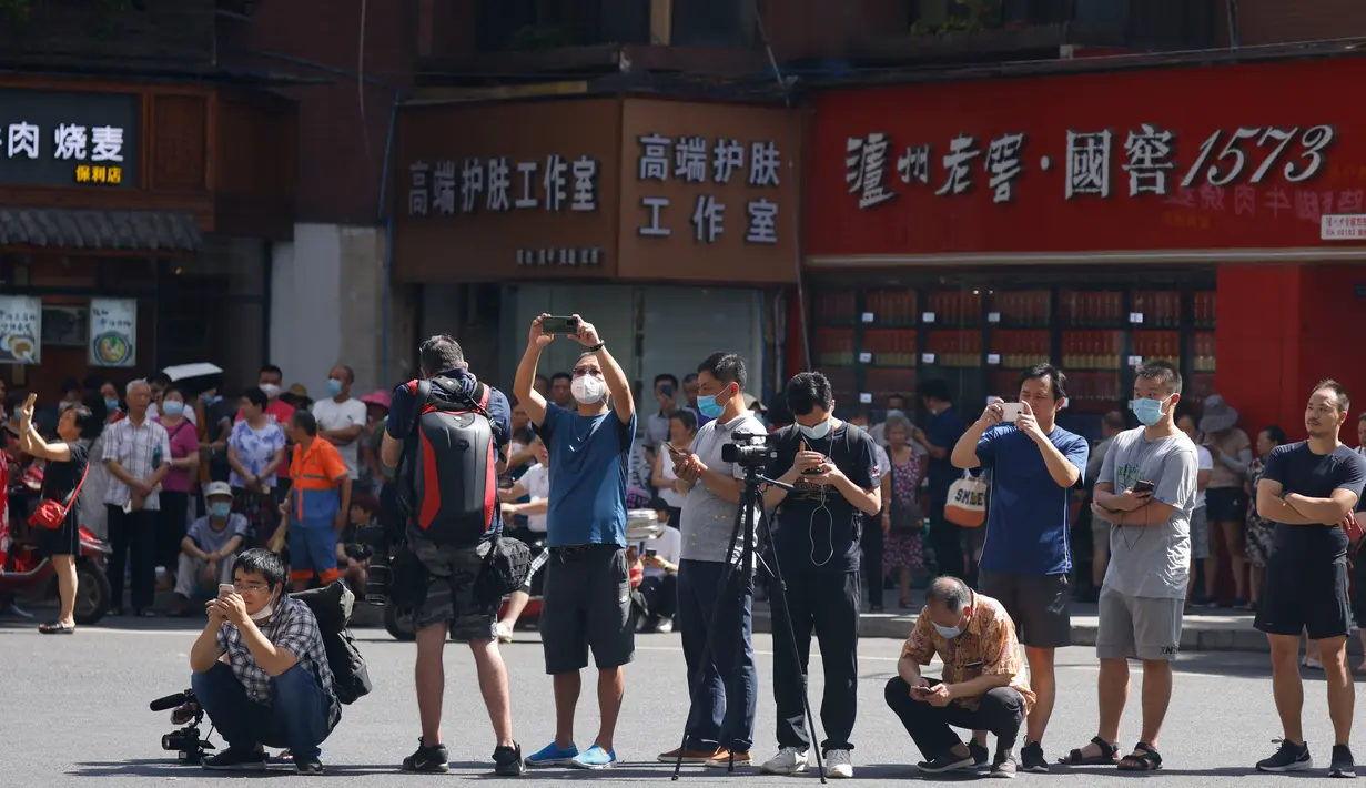 Warga dan wartawan berkumpul ketika pihak berwenang China mengamankan Konsulat Amerika Serikat di Chengdu, Senin (27/7/2020). Para diplomat Amerika Serikat meninggalkan konsulat AS di Kota Chengdu, menyusul keputusan Beijing untuk menutup kantor tersebut. (AP Photo/Ng Han Guan)