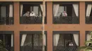 Orang-orang berdiri di balkon mereka di hotel H10 Costa Adeje Palace di Pulau Canary Tenerife, Spanyol, Selasa, (25/2/2020). Pemerintah Spanyol mengatakan sekitar 1.000 orang di Hotel H10 tersebut diisolasi usai adanya temuan positif virus corona COVID-19. (AP Photo)