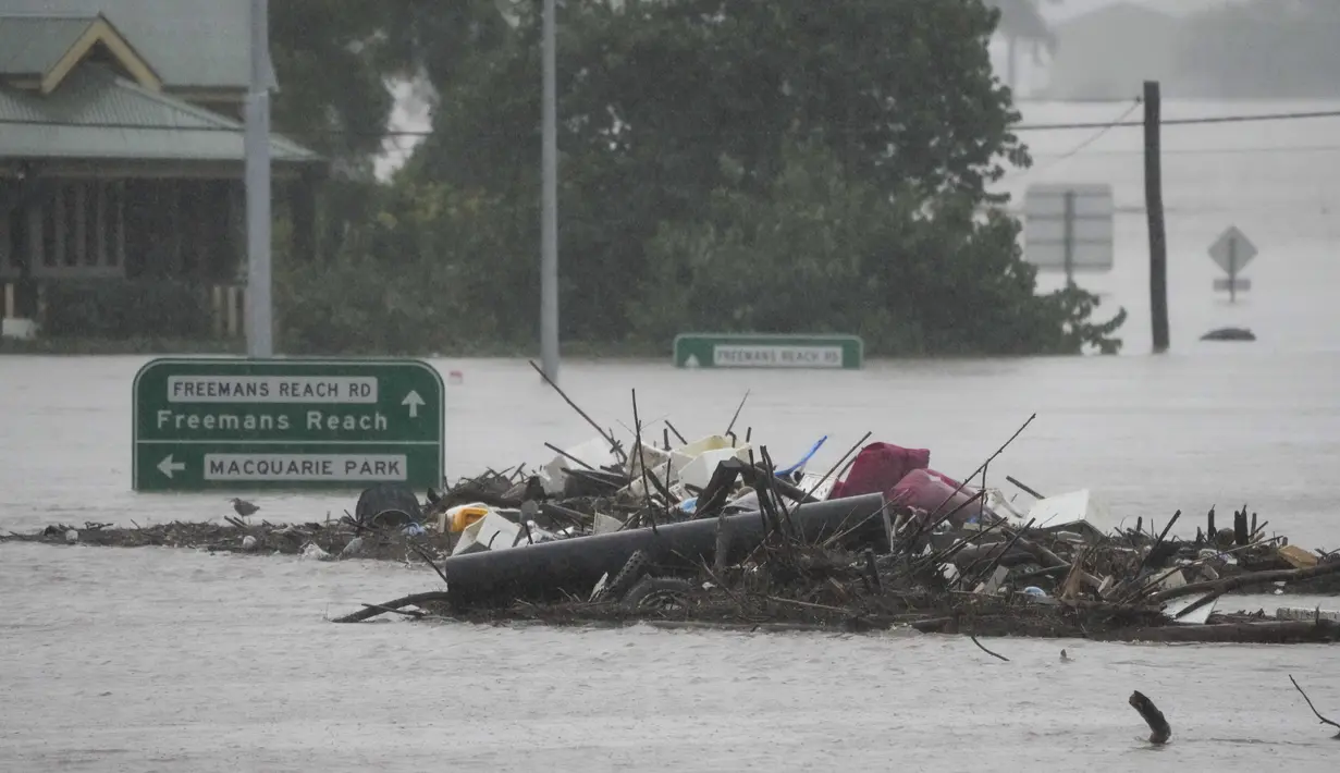 Puing-puing berada di tengah Jembatan Windsor yang terendam banjir di pinggiran Sydney, Australia, Senin (4/7/2022). Banjir kali ini merupakan yang terparah bagi kota terbesar di Australia tersebut selama 18 bulan terakhir. (AP Photo/Mark Baker)