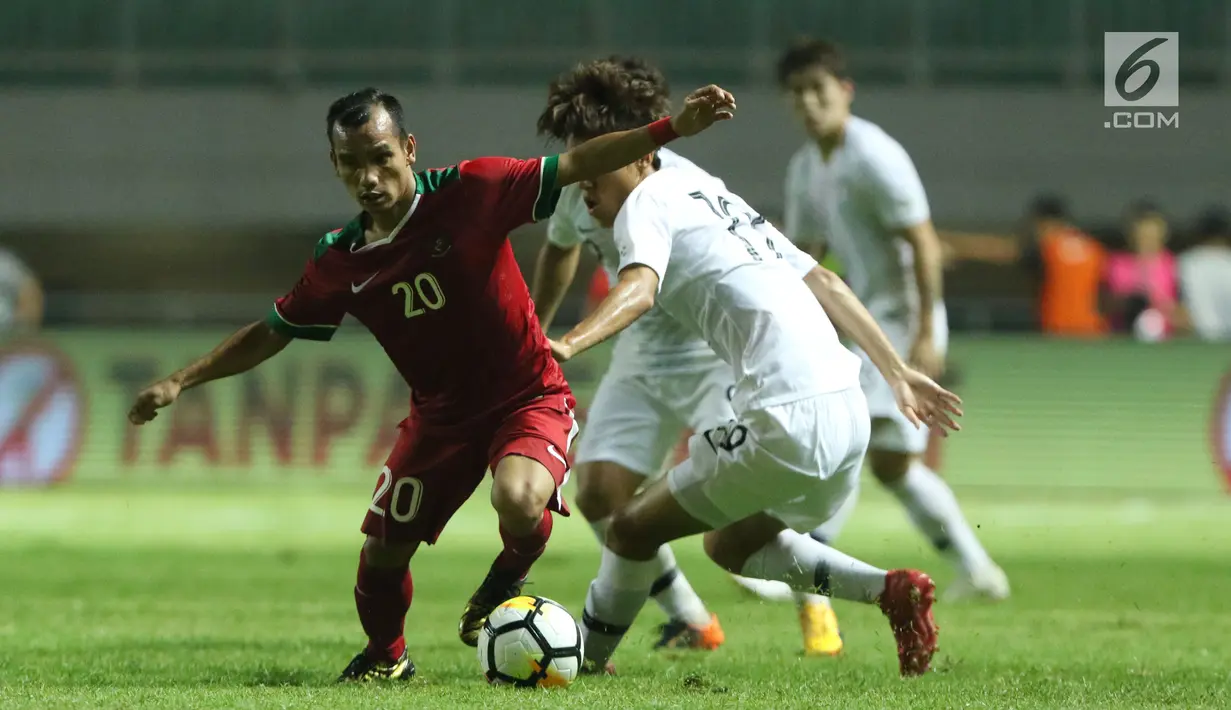 Pemain sayap Timnas Indonesia U-23. Riko Simanjuntak (kiri) berebut bola dengan pemain Korea Selatan U-23 pada laga persahabatan di Stadion Pakansari, Kab Bogor, Sabtu (23/6). Babak pertama Indonesia U-23 tertinggal 0-1. (Liputan6.com/Helmi Fithriansyah)