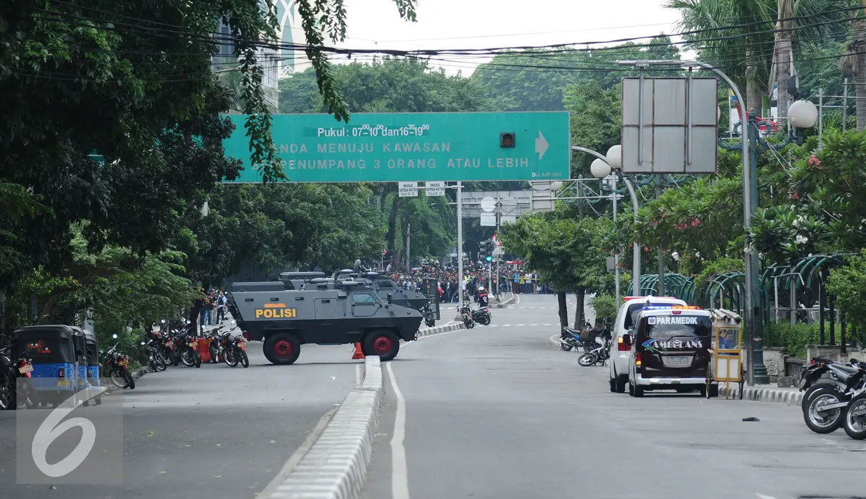 Sejumlah kendaraan petugas berjaga di sekitar perempatan jalan Wahid Hasyim Jakarta atau lokasi tempat pengeboman, Kamis (14/1/2016). Polisi mencurigai seorang melakukan aksi bom bunuh diri. (Liputan6.com/Helmi Fitriansyah)