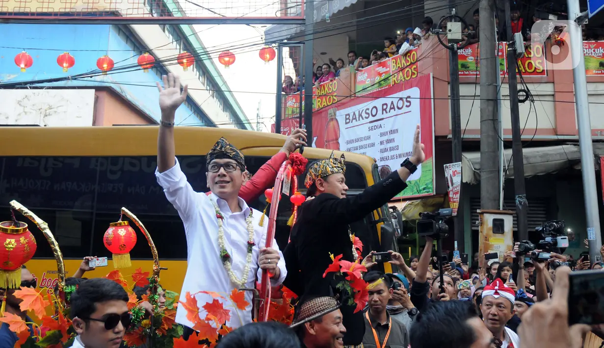 Menteri Pariwisata dan Ekonomi Kreatif Wishnutama (kiri) dan Wali Kota Bogor Bima Arya menyapa warga saat Bogor Street Festival Cap Go Meh (CGM) 2020 yang digelar di Jalan Surya Kencana, Kota Bogor, Jawa Barat, Sabtu (8/2/2020). (Liputan6.com/Helmi Fithriansyah)