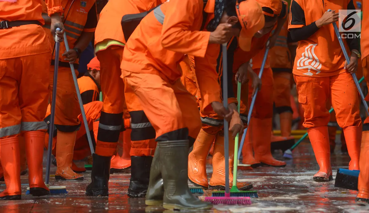 Petugas PPSU membersihkan trotoar di Jalan Asia Afrika, Jakarta, Kamis (2/8). Trotoar yang di pakai para pedagang kaki lima ini di bersihkan guna jelang Asian Games 2018 di Jakarta dan Palembang. (Merdeka.com/Imam Buhori)