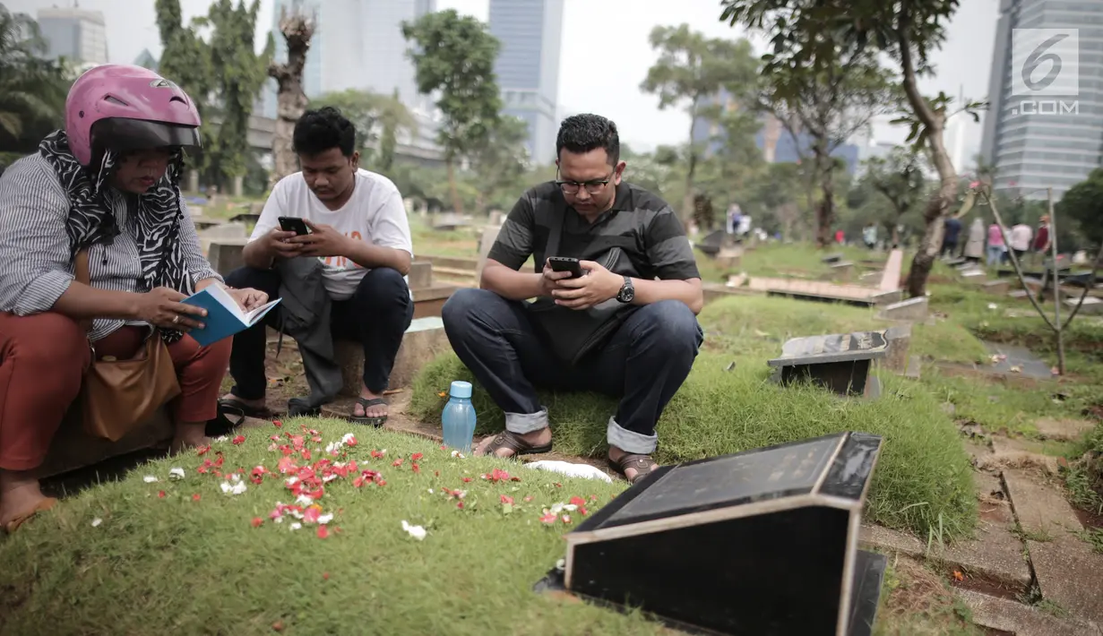 Sejumlah warga berdoa di makam keluarga saat ziarah kubur di Tempat Pemakaman Umum (TPU) Menteng Pulo, Jakarta, Minggu (28/4/2019). Tradisi ziarah kubur dilakukan umat Muslim menjelang datangnya bulan suci Ramadan untuk mendoakan keluarga mereka yang telah wafat. (Liputan6.com/Faizal Fanani)
