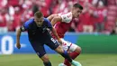 Pada menit ke-30 lagi-lagi peran krusial Lukas Hradecky ditunjukkan saat mampu memotong umpan silang dari Joakim Maehle (kanan) ke arah tiang jauh yang sudah ditunggu Yussuf Poulsen. (Foto: AP/Martin Meissner/Pool)